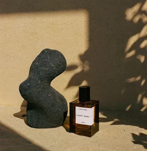 Escultura de pedra e frasco de perfume